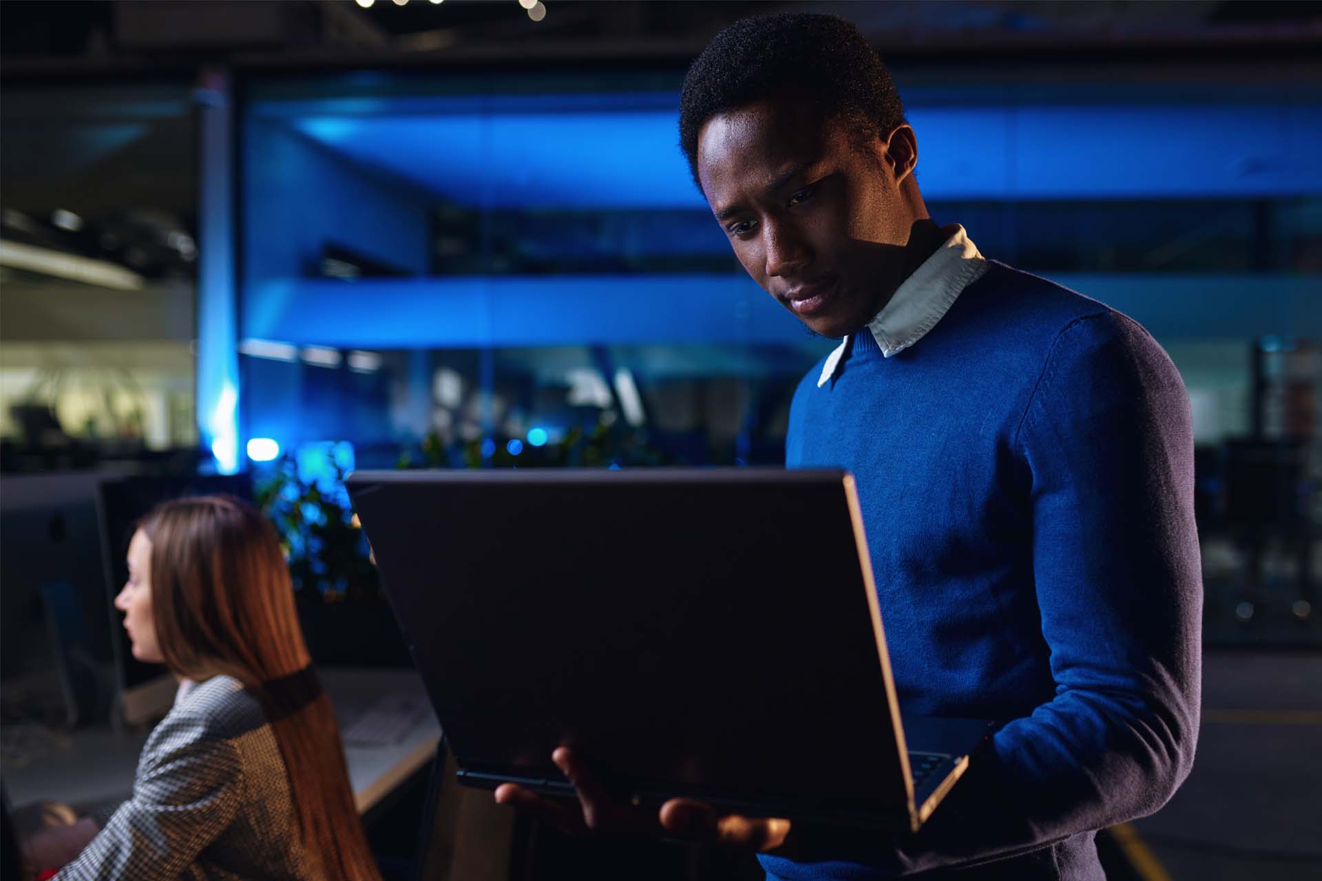 KPIs2 African American IT consultant standing in the office holding a laptop in his hands