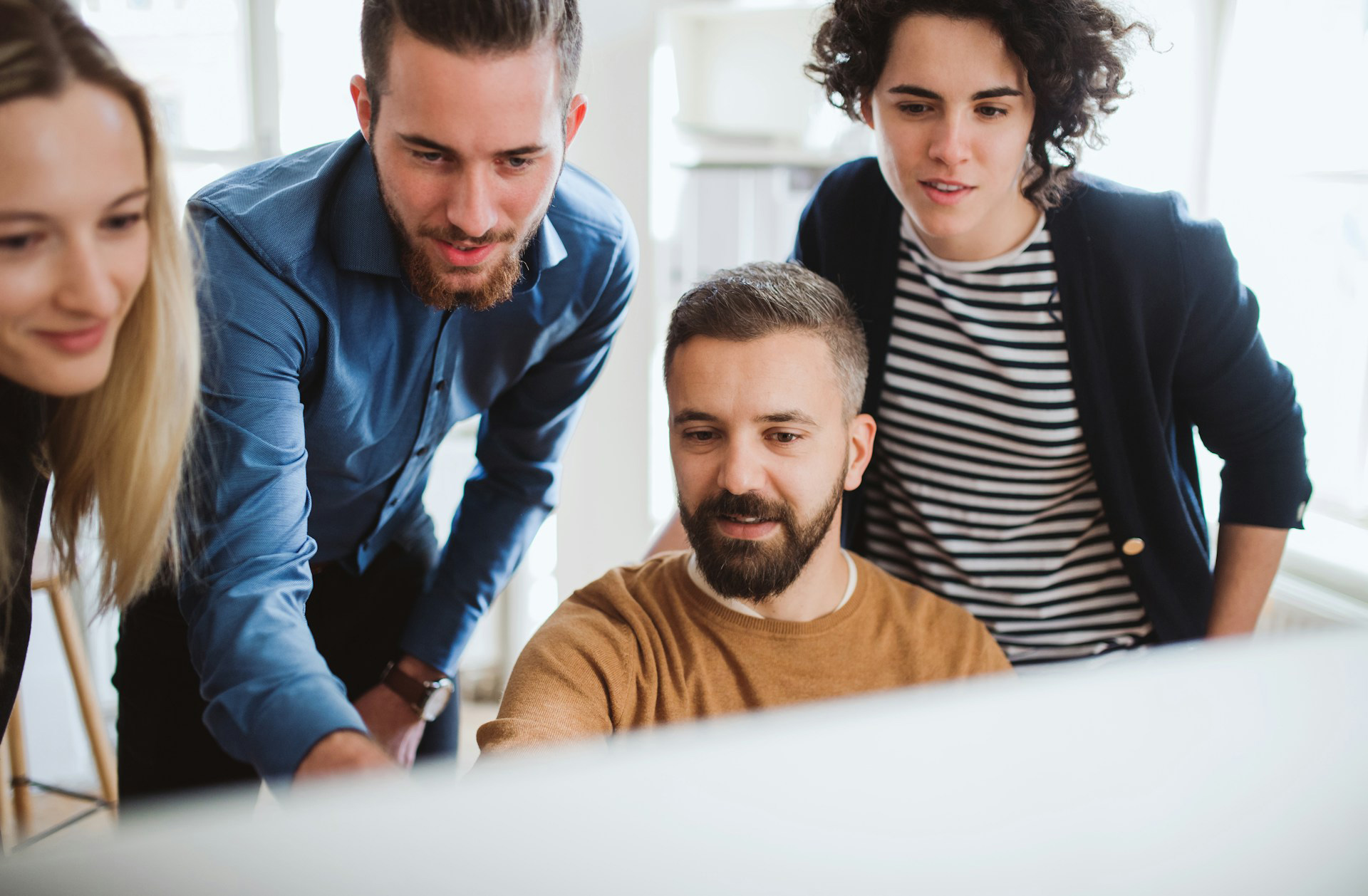 A group of healthcare consultants collaborating in front of a monitor